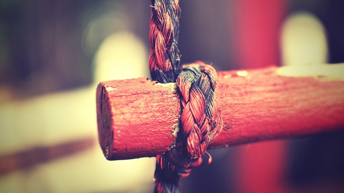 Rope tied to a red wooden bar