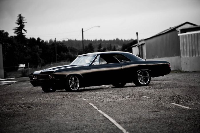 Black classic muscle car parked on asphalt