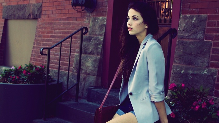 Emily Rudd sitting on steps with flowers