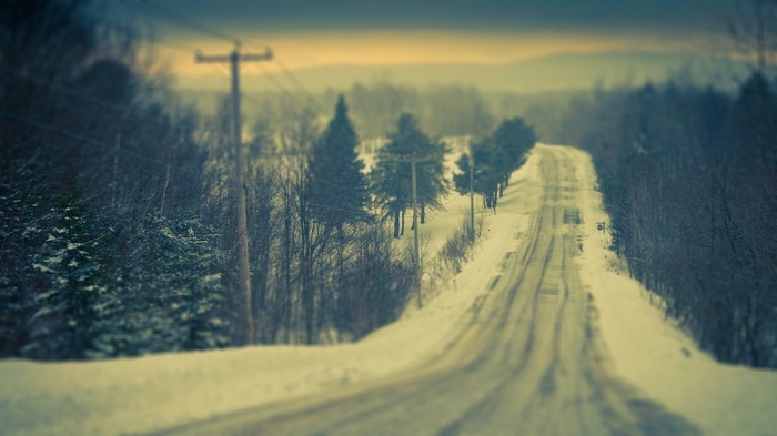 Winter road through a snowy forest landscape