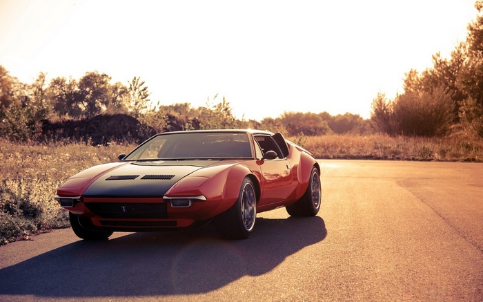 Red DeTomaso Pantera sports car on a road