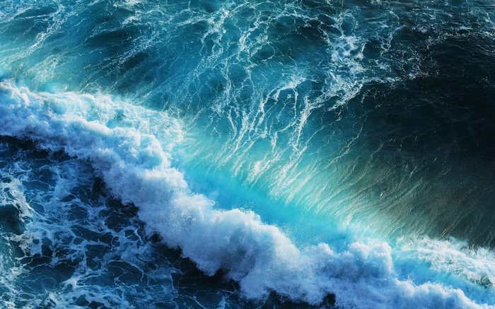Ocean waves crashing with turquoise and deep blue water