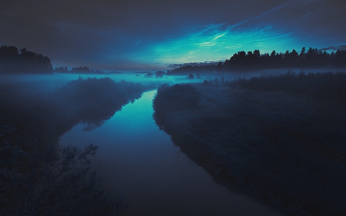 Misty river landscape at twilight with glowing clouds
