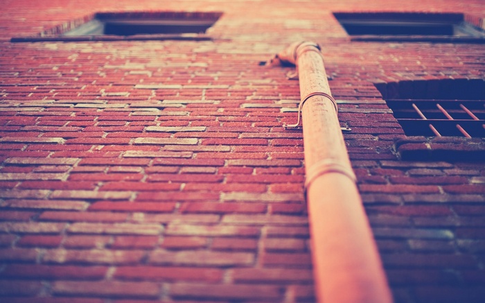 Worm's eye view of a brick wall with a drainpipe