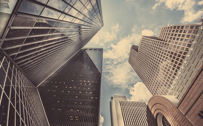 Skyscrapers viewed from below against a cloudy sky