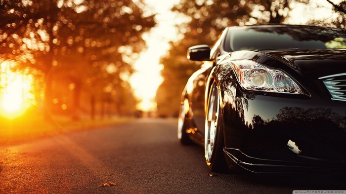 Black Lexus car at sunset on a road