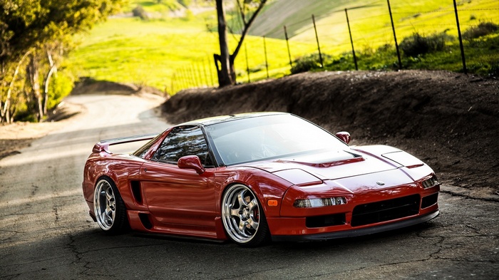 Red Honda NSX sports car on a winding road