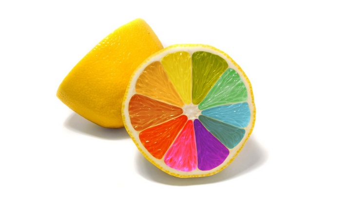 A colorful lemon slice and a whole lemon on a white background