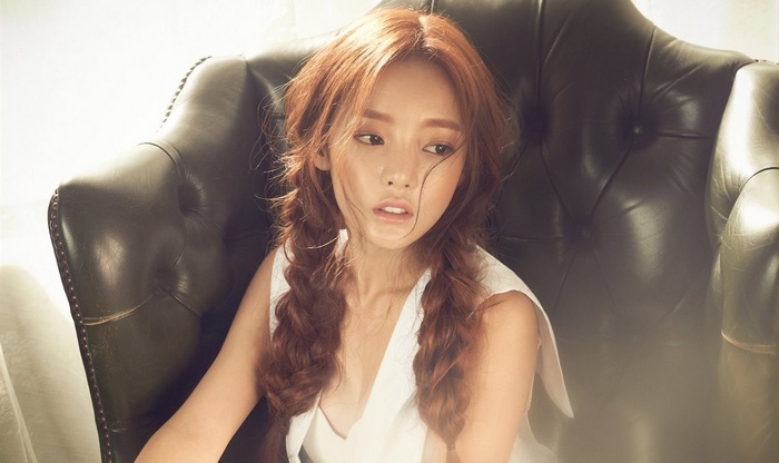 Hara from Kara sitting in a leather chair