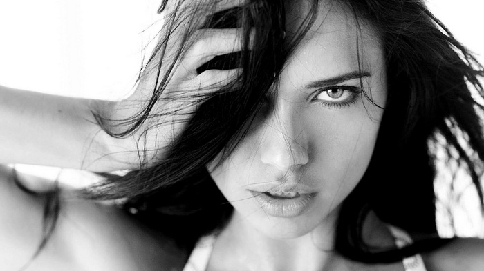 Adriana Lima with hands on head, monochrome portrait