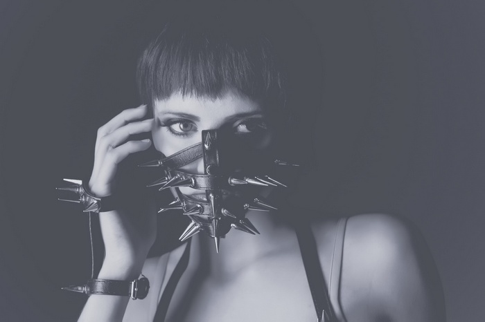 Woman wearing a spiked mask and wristbands