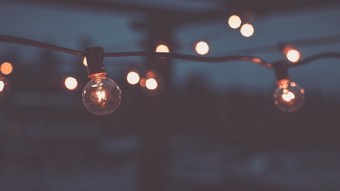 String of glowing light bulbs at night