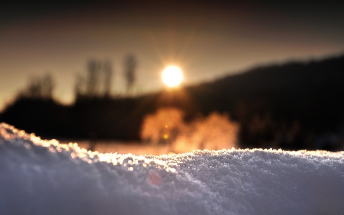 Sun setting over a snowy landscape with steam