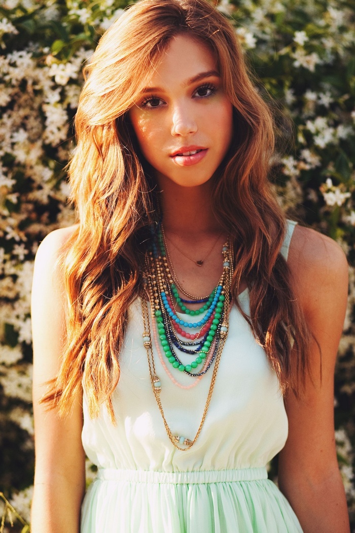 Alexis Ren wearing a white dress and necklace outdoors