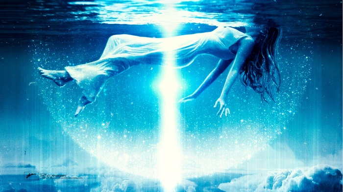 Woman floating underwater with bright light