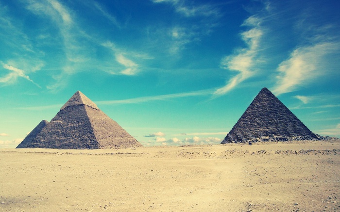 Pyramids of Giza under a cloudy blue sky