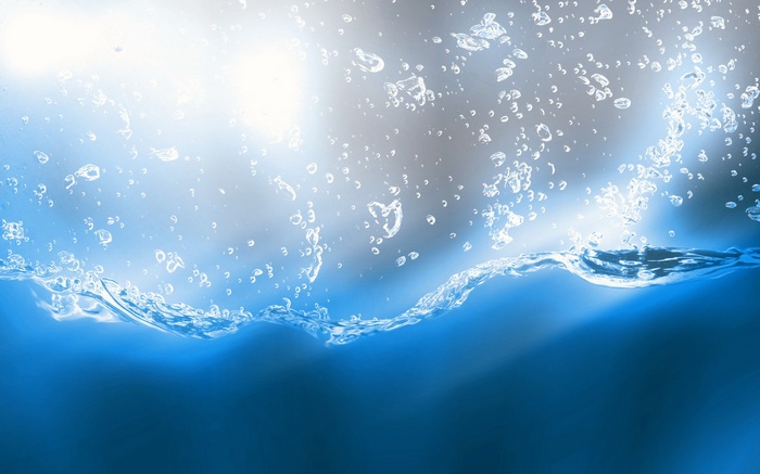 Bubbles rising in blue water with bright light