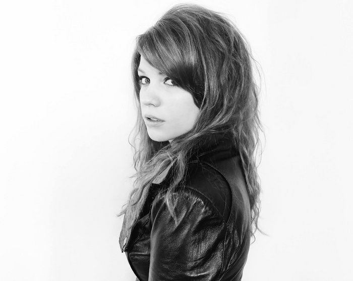 Nanalew in a leather jacket looking over her shoulder