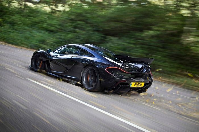 Black McLaren P1 driving on a road