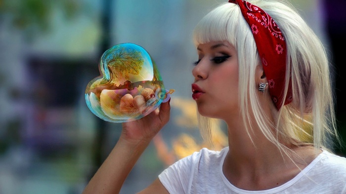 Woman blowing a heart-shaped bubble