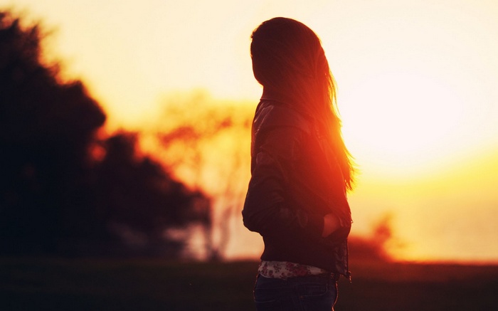 Woman in silhouette against a golden sunset