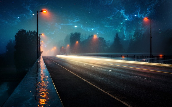 Night road with streetlights and nebula sky