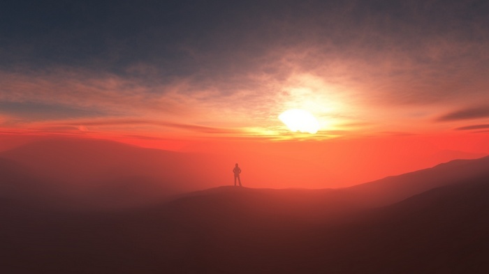 Silhouette of a person on a mountain at sunset