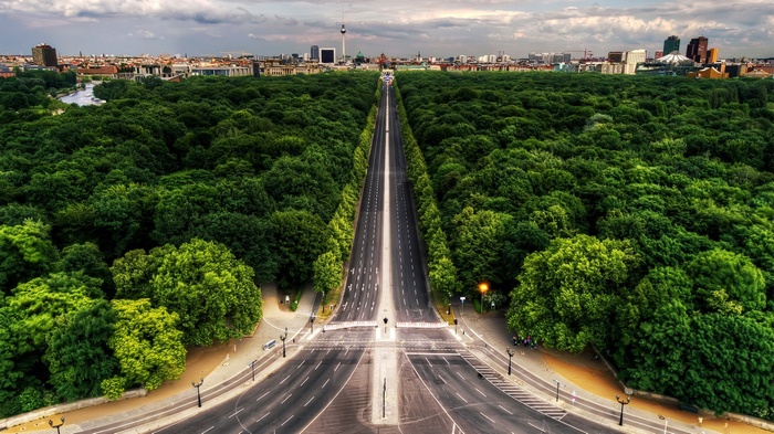 Berlin's Tiergarten avenue with cityscape in the background