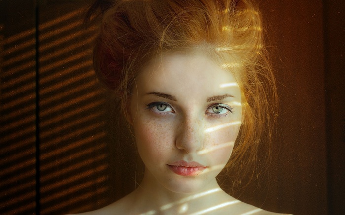 Portrait of a redhead woman with green eyes and freckles