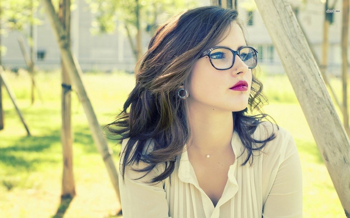 Woman with glasses and piercings outdoors
