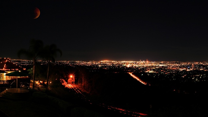 Brisbane cityscape at night with a lunar eclipse