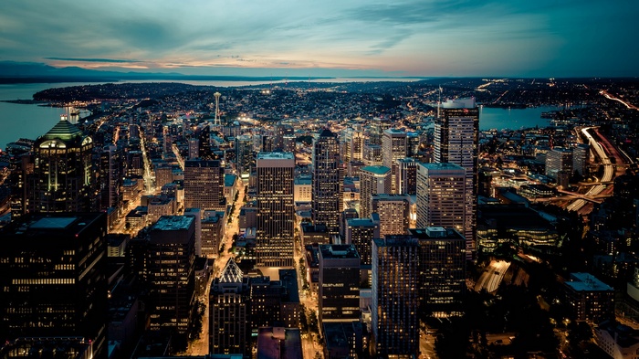 Seattle cityscape at night with water and mountains