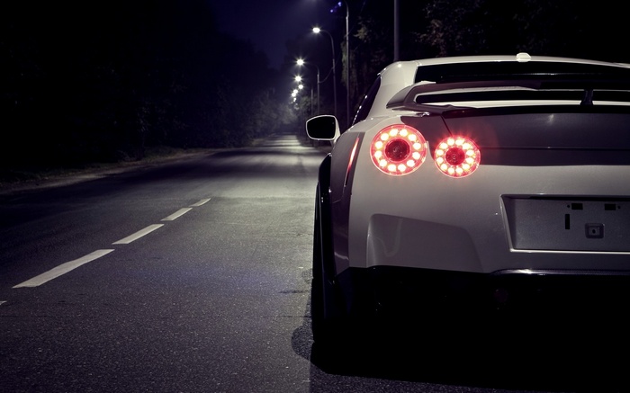 White Nissan GT-R R35 parked on a dark road at night