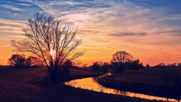 Sunset over a river with trees
