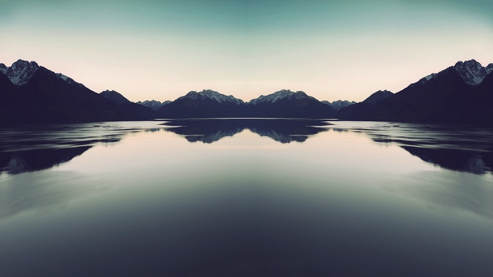 Symmetrical mountain reflection over a calm lake