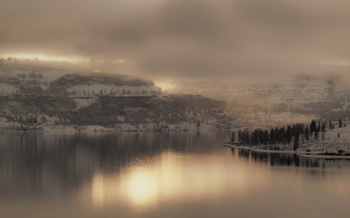 Winter landscape with snow-covered mountains and a lake