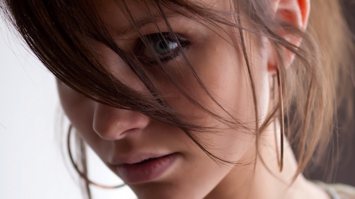 Woman with hair in face and hoop earrings