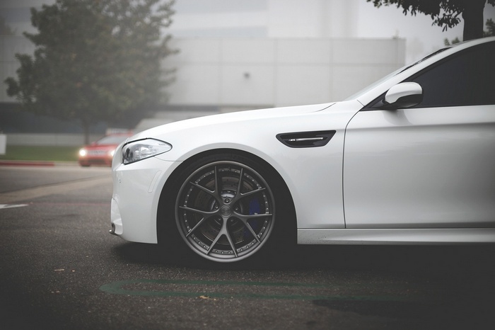 White BMW M5 F10 side profile with custom wheels