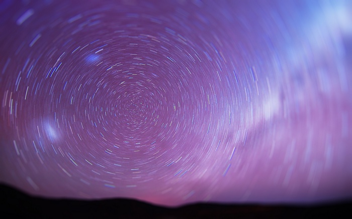 Star trails in a purple and pink sky