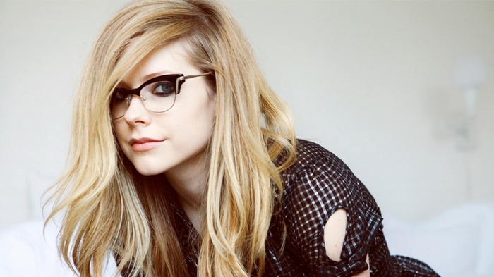 Avril Lavigne wearing glasses and a plaid shirt