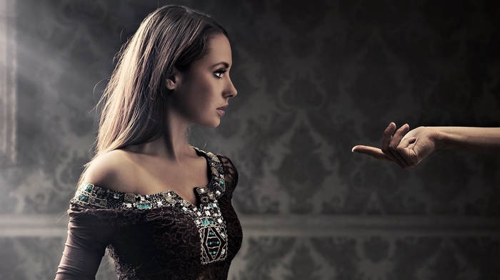 Woman in ornate dress with hand reaching out