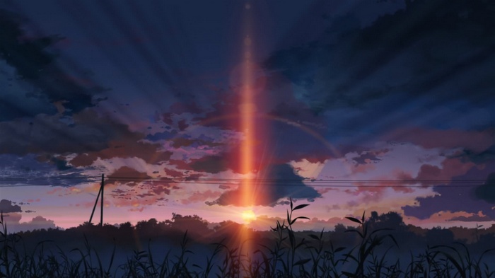 Sunset over a field with a light beam