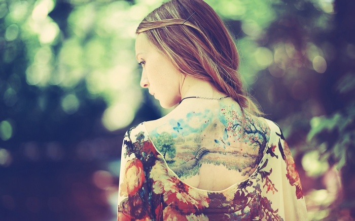Woman with a large landscape tattoo on her back