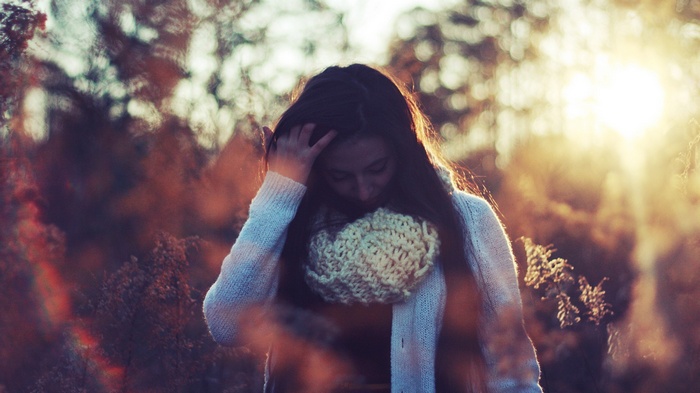 Woman with hands on head in sunlight