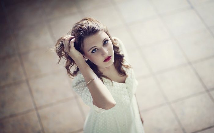 Woman with hands on head in white dress
