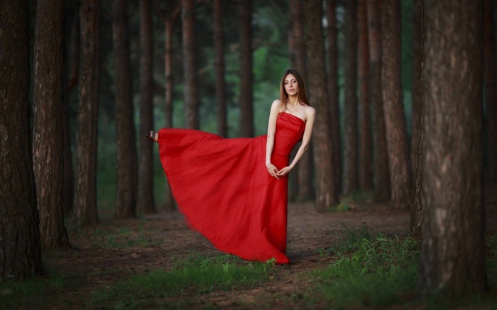 Woman in a red dress in a forest