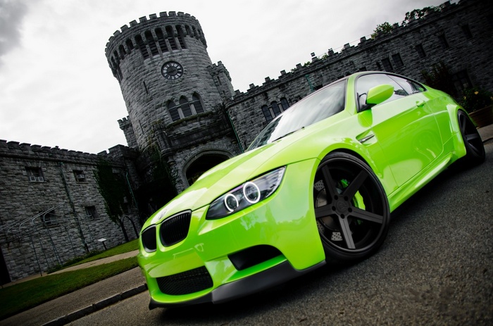 Green BMW M3 parked in front of a castle