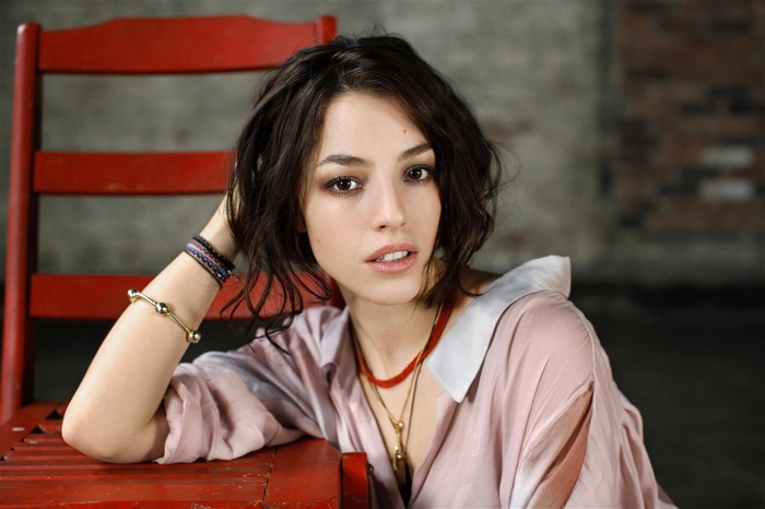 Olivia Thirlby sitting on a red chair
