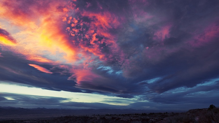 Dramatic sunset clouds over a dark landscape