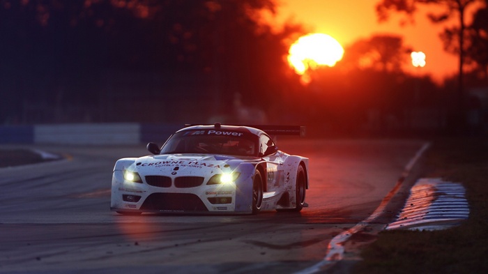 BMW Z4 race car at sunset on a track